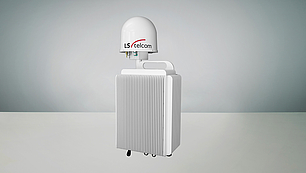 A compact white signal monitoring unit with a ribbed cooling design and a dome-shaped antenna on top labeled 'LS telcom'. The unit features connection ports beneath the antenna for signal input and output.