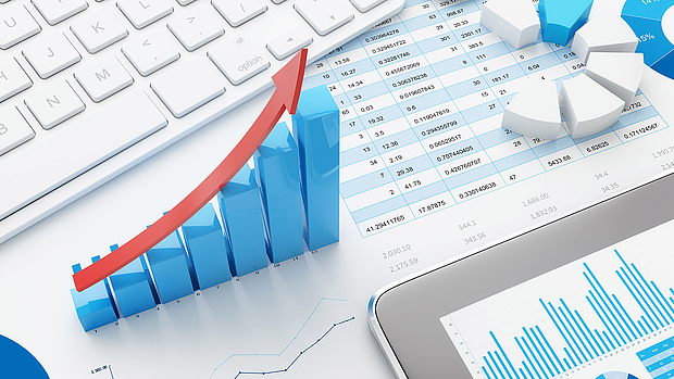 3D bar chart with an upward red arrow on financial documents, symbolizing LS telcom’s network optimization and expansion services for improved coverage, cost efficiency, and QoS.